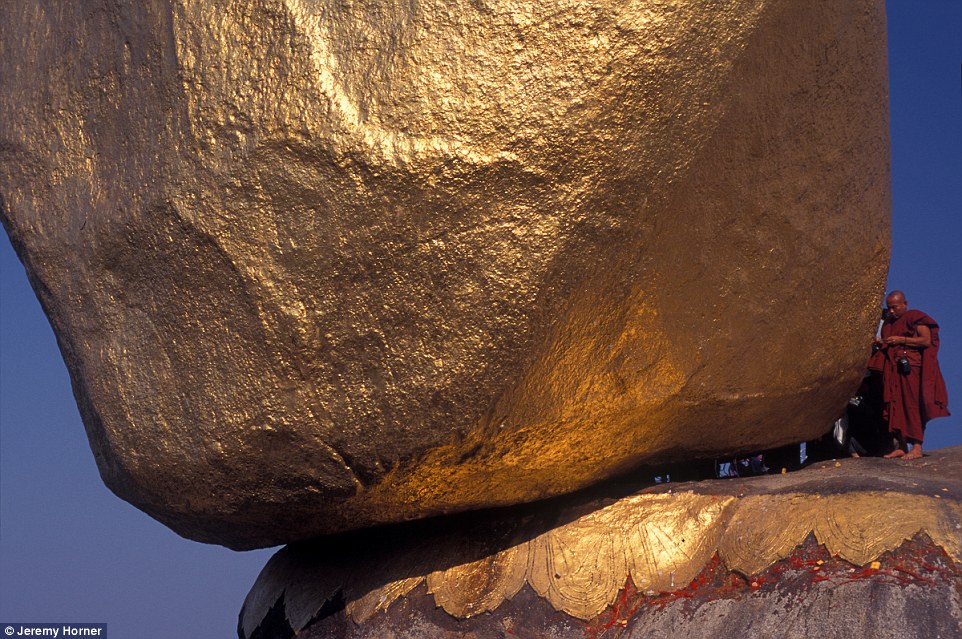 Монах совершает паломничество к пагоде Чайттийо, которую также называют Золотым камнем, в Мьянме.